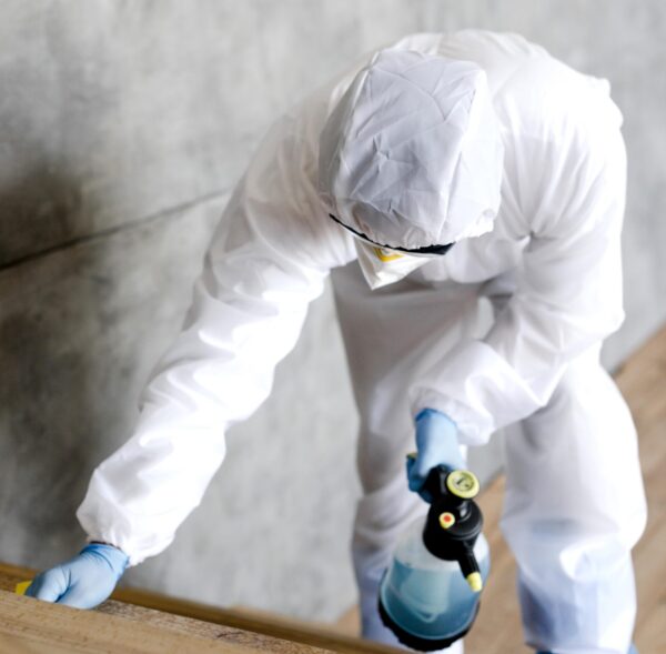full-shot-man-with-suit-disinfecting-stairs