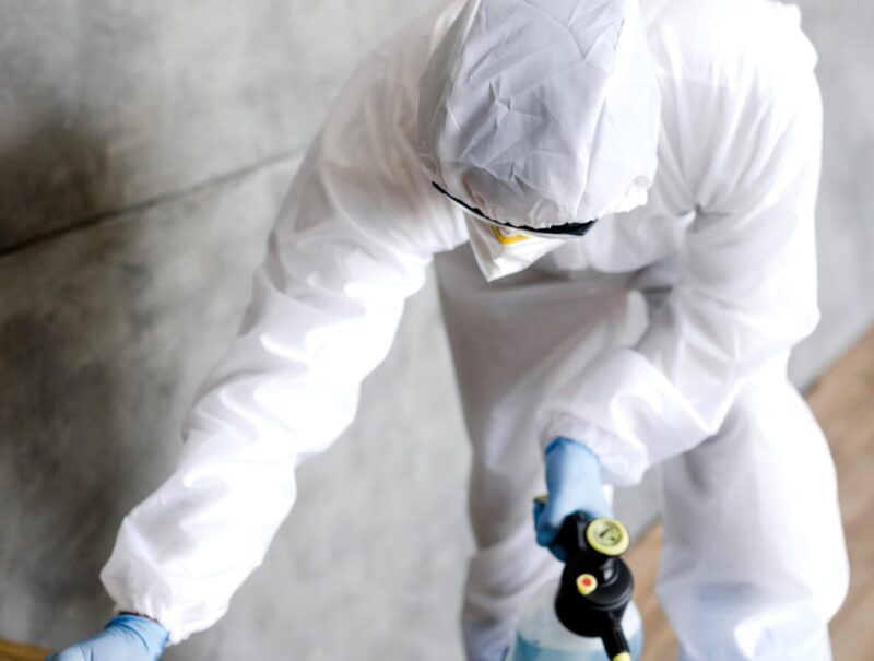 full-shot-man-with-suit-disinfecting-stairs